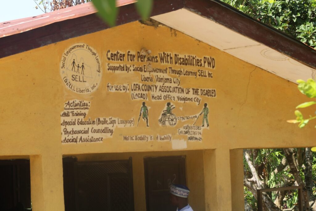 A signboard for the Center for Persons with Disabilities listing skills training, special education, psychosocial counselling and social assistance.