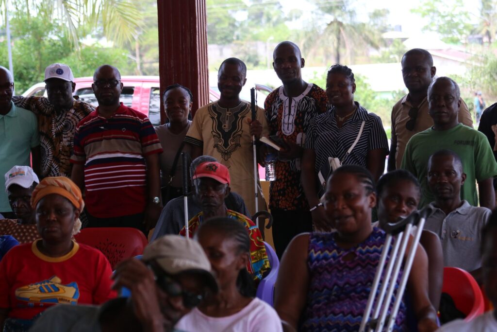 A crowded hall of community members, several with crutches, attending a Commission engagement meeting.