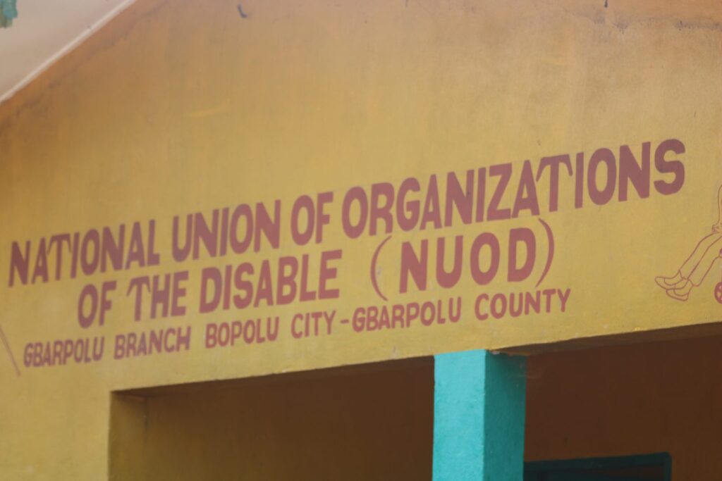A building painted with the sign 'National Union of Organizations of the Disable (NUOD), Gbarpolu Branch, Bopolu City, Gbarpolu County'.