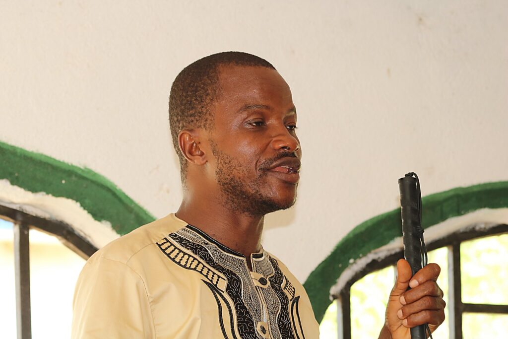 A man holding a microphone as he speaks at a community meeting.